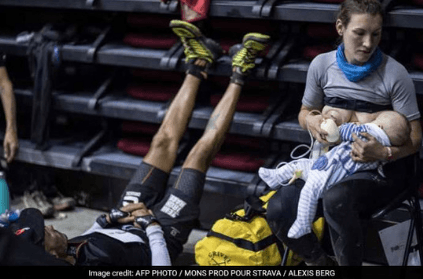 Mother breastfeeds baby during race